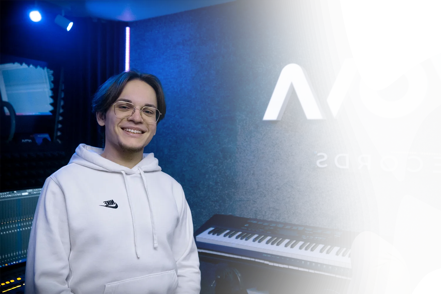 Звукорежиссёр Nova Records в студии на фоне светящейся вывески NOVA и микшерного пульта
